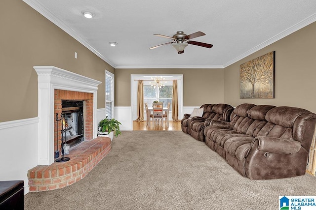 living room with carpet, ornamental molding, a fireplace, and ceiling fan