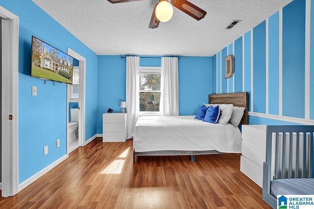 bedroom with a textured ceiling, wood-type flooring, and ceiling fan