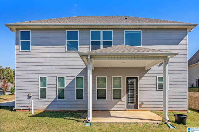 rear view of house with a yard and a patio area