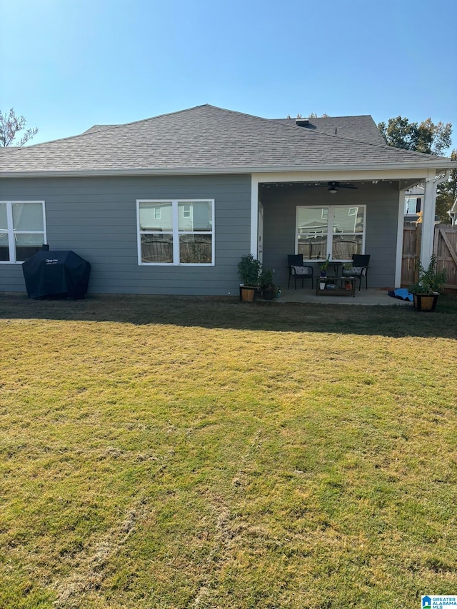 rear view of property featuring a yard, a patio area, and ceiling fan