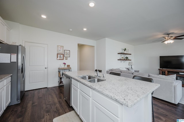 kitchen with sink, an island with sink, dark hardwood / wood-style flooring, stainless steel appliances, and white cabinets