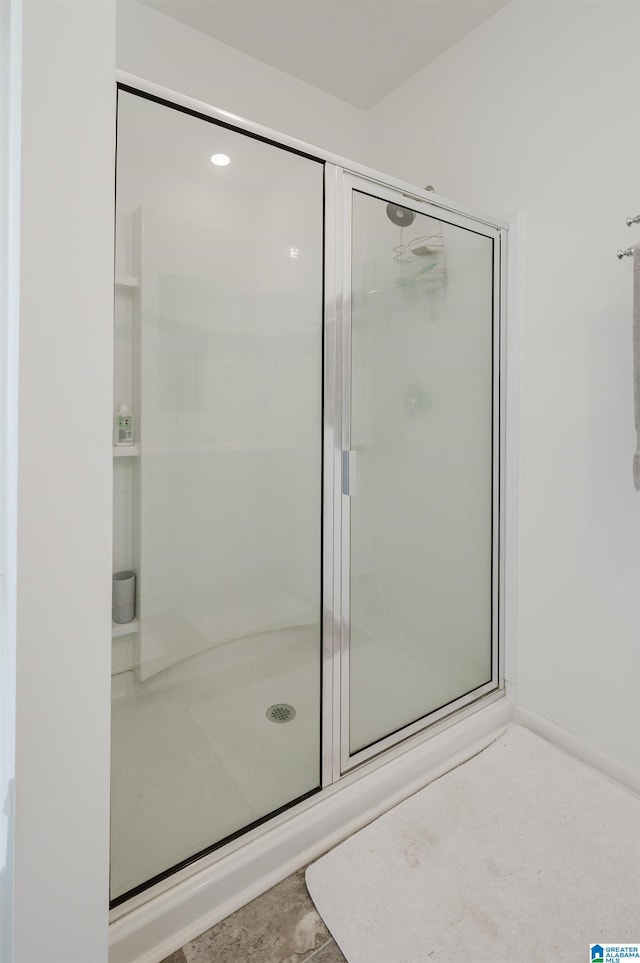 bathroom with a shower with shower door and tile patterned flooring