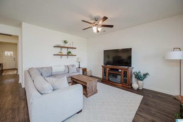 living room featuring dark wood-type flooring and ceiling fan