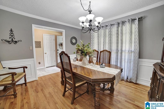 dining area with crown molding, an inviting chandelier, and a textured ceiling