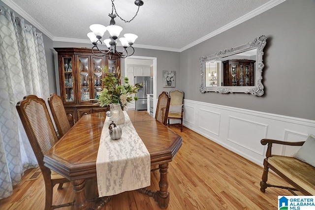 dining area with an inviting chandelier, crown molding, light hardwood / wood-style floors, and a textured ceiling