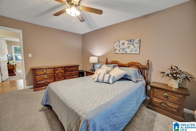 carpeted bedroom featuring a textured ceiling and ceiling fan