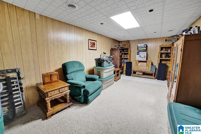 sitting room featuring carpet and wooden walls