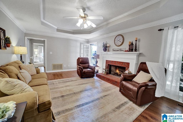 living room featuring ornamental molding, a tray ceiling, and hardwood / wood-style floors