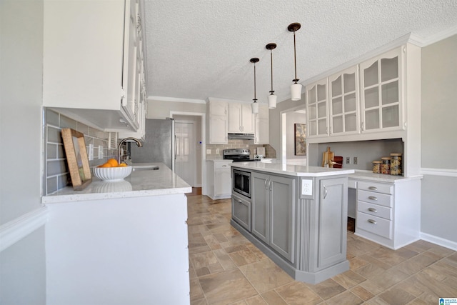 kitchen featuring sink, appliances with stainless steel finishes, hanging light fixtures, white cabinets, and a kitchen island