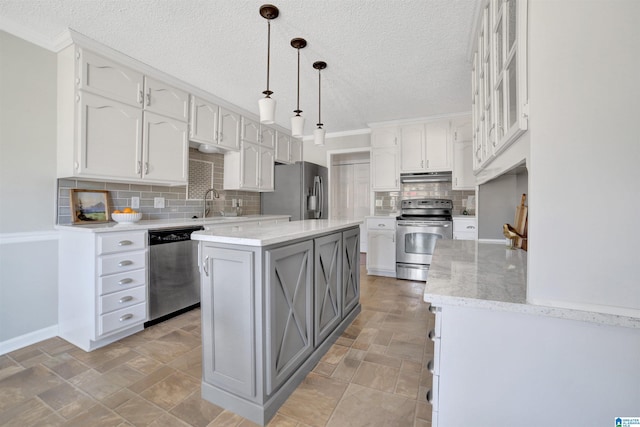 kitchen with white cabinetry, hanging light fixtures, stainless steel appliances, and a kitchen island