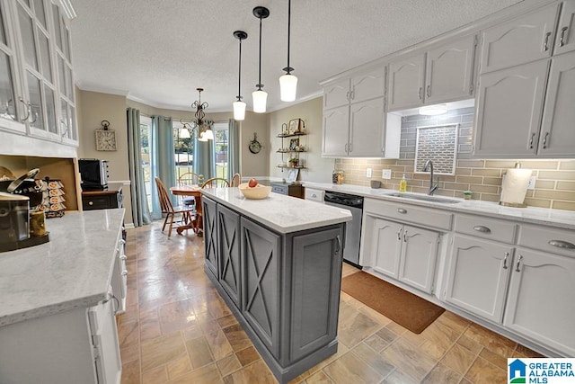 kitchen with white cabinetry, decorative light fixtures, a center island, stainless steel dishwasher, and decorative backsplash