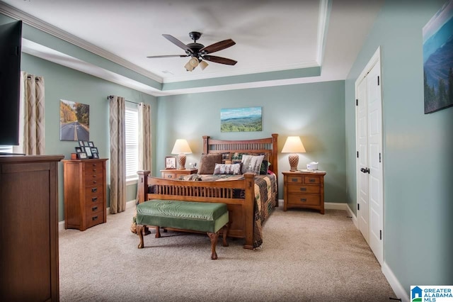 bedroom featuring crown molding, light colored carpet, a tray ceiling, and ceiling fan