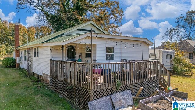 view of front of house with a deck and a front lawn