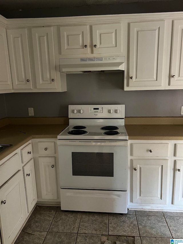 kitchen with white cabinets, dark tile patterned floors, and white range with electric cooktop