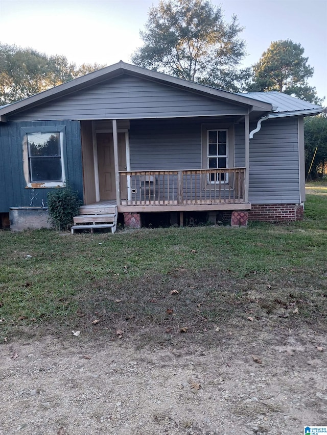 view of front of house with a front yard and covered porch