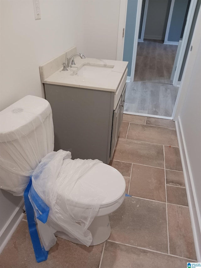 bathroom with vanity, toilet, and wood-type flooring