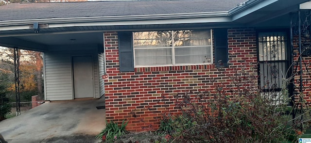 view of property exterior with brick siding and roof with shingles