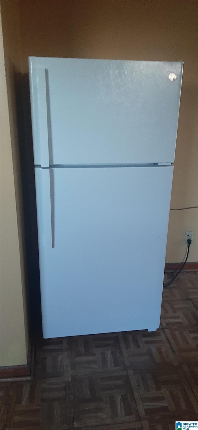 room details featuring baseboards and freestanding refrigerator