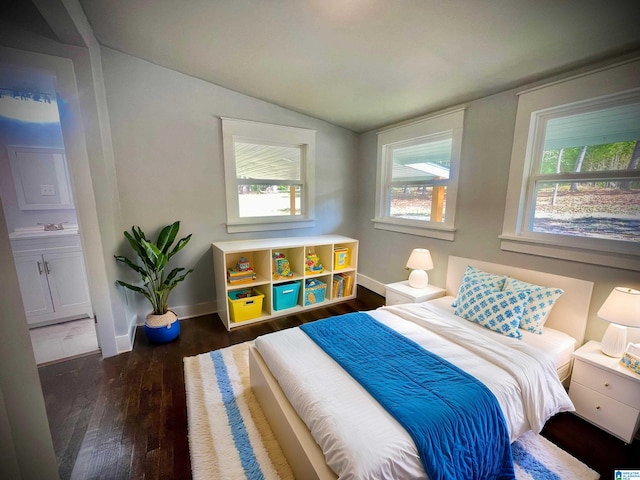 bedroom featuring ensuite bath, lofted ceiling, multiple windows, and dark hardwood / wood-style floors