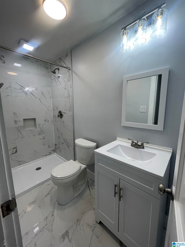 bathroom with toilet, vanity, and tiled shower