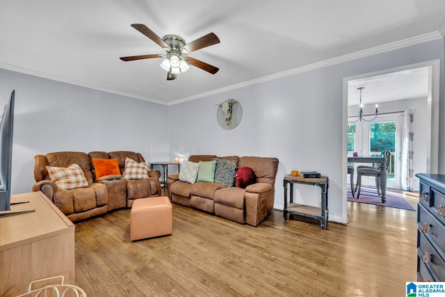 living room featuring ornamental molding, light wood-type flooring, and ceiling fan with notable chandelier