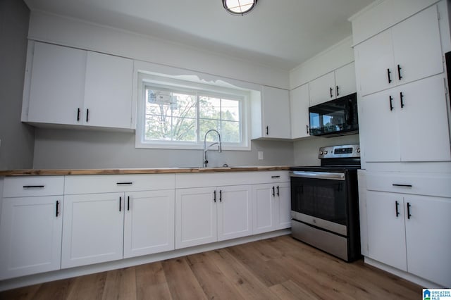 kitchen featuring stainless steel electric stove, white cabinets, and sink