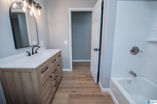 bathroom with vanity, hardwood / wood-style floors, and tiled shower / bath combo