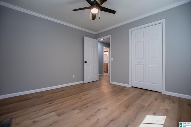 unfurnished bedroom featuring ceiling fan, crown molding, and light wood-type flooring