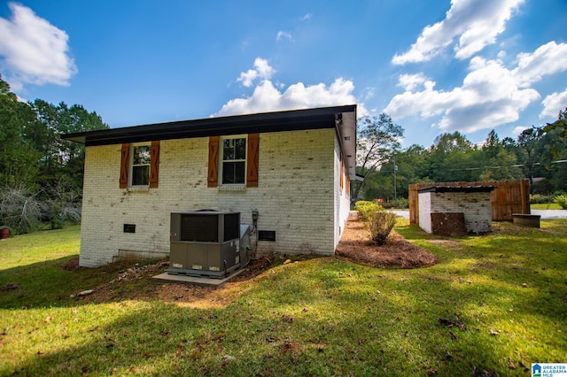 rear view of house with a yard and cooling unit