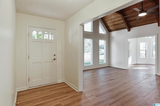 foyer entrance featuring ceiling fan, vaulted ceiling with beams, light hardwood / wood-style floors, and wooden ceiling