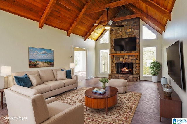 living room with beam ceiling, ceiling fan, high vaulted ceiling, dark wood-type flooring, and a stone fireplace