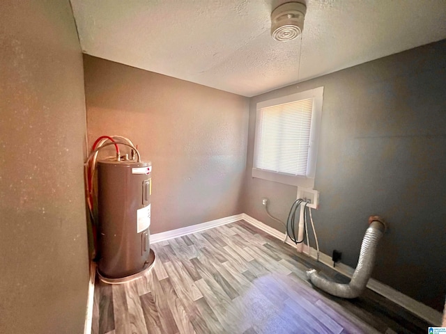 interior space with light hardwood / wood-style flooring, electric water heater, and a textured ceiling