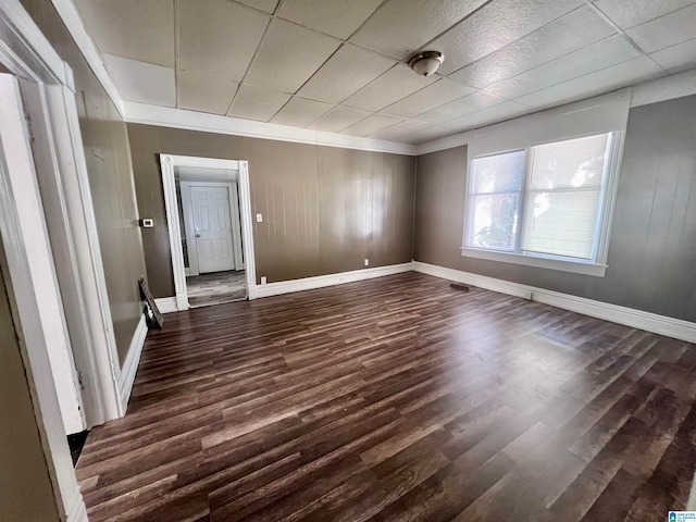 unfurnished room featuring wood walls and dark hardwood / wood-style floors