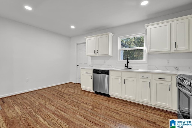 kitchen featuring white cabinets, sink, light wood-type flooring, and stainless steel appliances