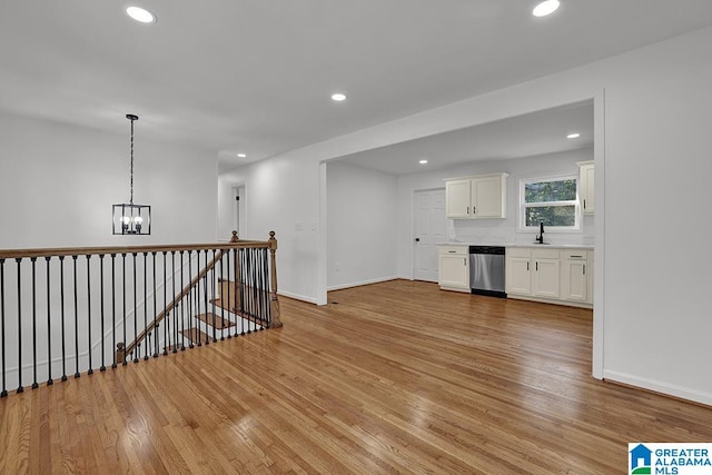 unfurnished room with sink, light hardwood / wood-style flooring, and an inviting chandelier