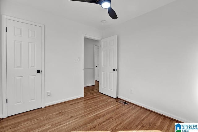 unfurnished bedroom with ceiling fan and wood-type flooring