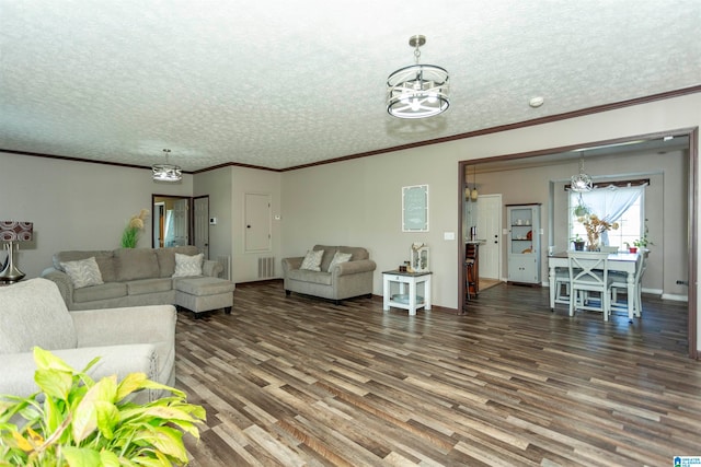 living room with crown molding, a textured ceiling, wood-type flooring, and an inviting chandelier