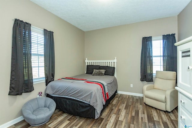 bedroom with dark wood-type flooring, multiple windows, and a textured ceiling