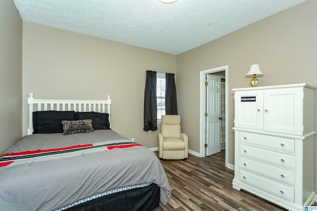 bedroom with a textured ceiling and dark hardwood / wood-style flooring