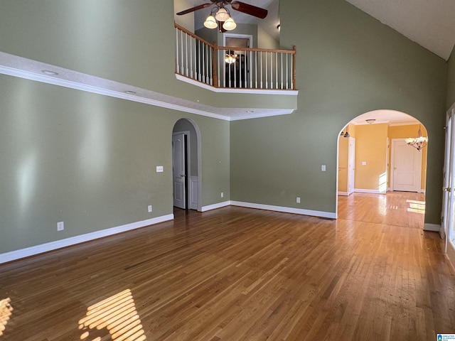 unfurnished living room with hardwood / wood-style flooring, high vaulted ceiling, and ceiling fan