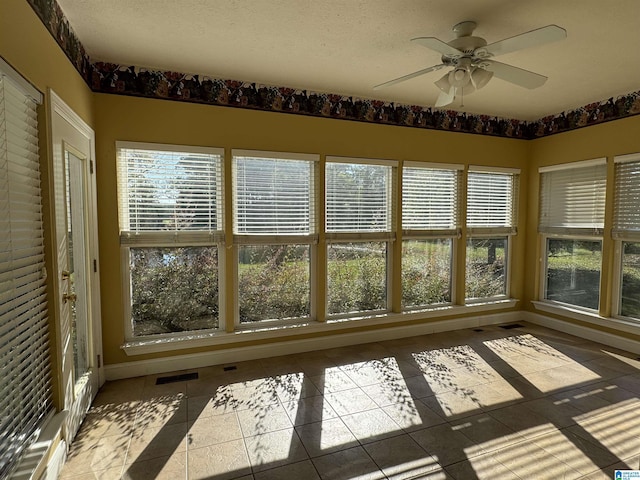 unfurnished sunroom featuring ceiling fan