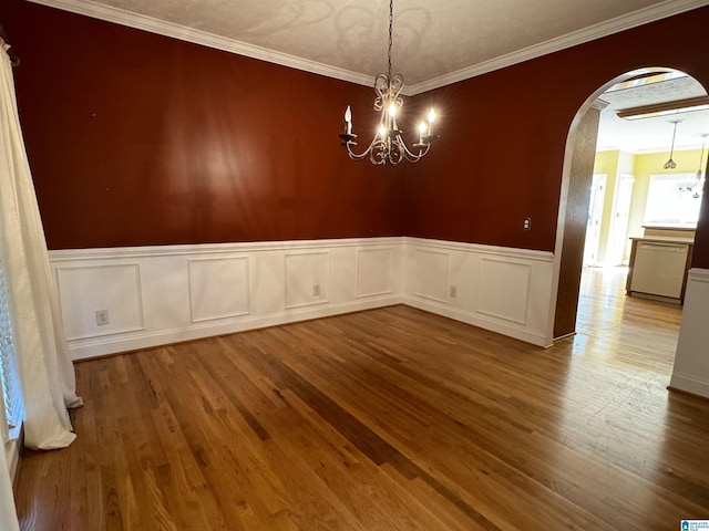 unfurnished dining area with light hardwood / wood-style flooring, ornamental molding, and an inviting chandelier