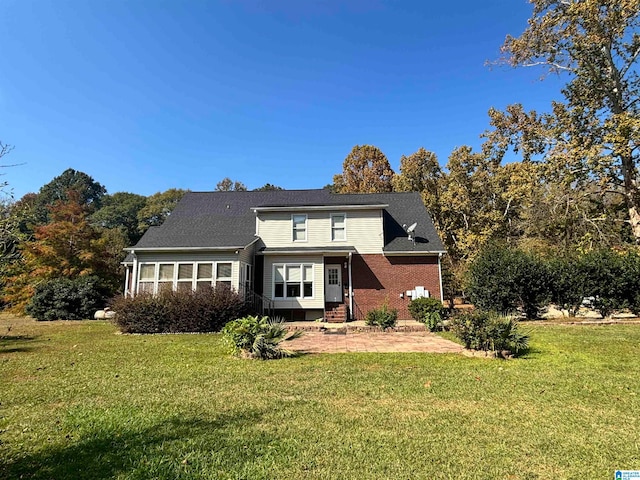 rear view of house featuring a yard and a patio