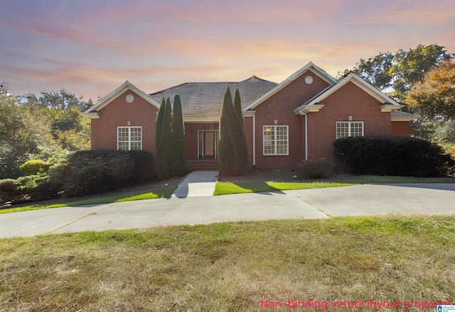 ranch-style home with a yard