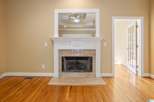 interior details with ceiling fan, hardwood / wood-style flooring, and a raised ceiling