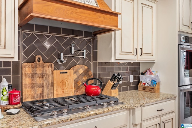 kitchen featuring light stone counters, stainless steel appliances, and decorative backsplash