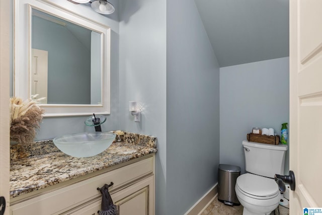 bathroom featuring vanity, vaulted ceiling, toilet, and tile patterned flooring