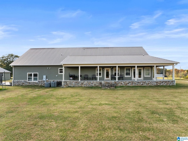 back of house featuring central air condition unit, covered porch, and a lawn