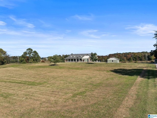 view of yard featuring a rural view and an outdoor structure