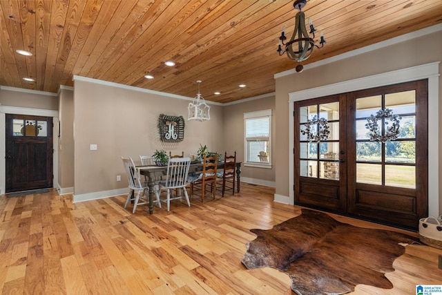 dining area featuring wood ceiling, a chandelier, light hardwood / wood-style flooring, crown molding, and french doors